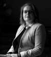 PHOTO CLAIRE EN NOIR ET BLANC ASSISE SUR UNE CHAISE HABILEE EN TAILLEUR